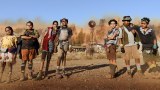 A group of seven indigenous kids with a duststorm approaching